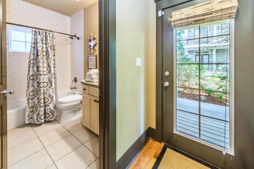 a bathroom with a toilet and a window at Comfort and Joy in Seacrest