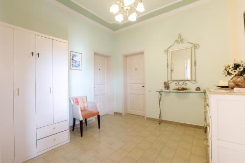 a living room with a mirror and a chair at Molfetta Beach Hotel  in Gouvia