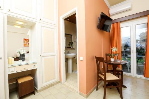 a room with a table and a bathroom with a sink at Molfetta Beach Hotel  in Gouvia