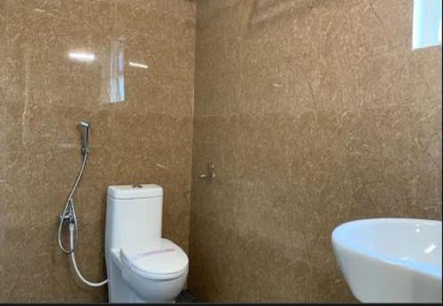 a bathroom with a white toilet and a sink at Sri Aadhish Grand Hotel in Arantāngi