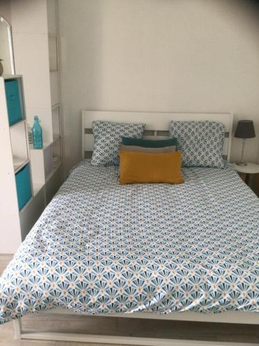 une chambre avec un lit avec une couette bleue et blanche dans l'établissement Studio terrasse vieux port-centre historique, à La Rochelle