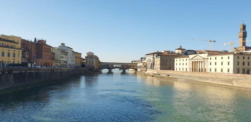 a river in a city with a bridge and buildings at appartamento pontevecchio in Florence