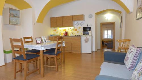 cocina y sala de estar con mesa y sillas en Apartman Pod Kostelem, en Polná