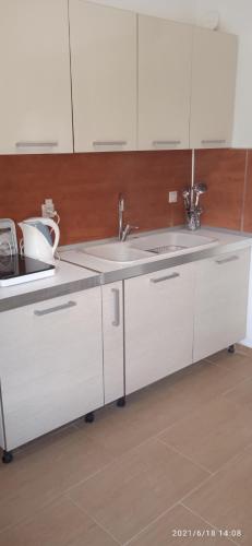 a kitchen with white cabinets and a sink at lemonishouse by the sea 1 in Nea Skioni