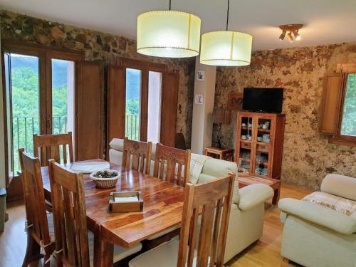 sala de estar con mesa de madera, sofá y comedor en Turismo Rural Casa del Batlle, en Sarroqueta