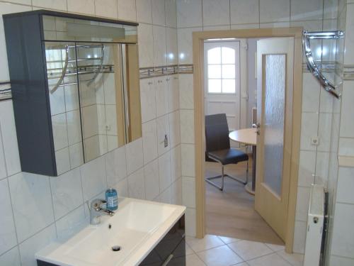 a bathroom with a sink and a mirror and a chair at Trothaer Eck in Kröllwitz