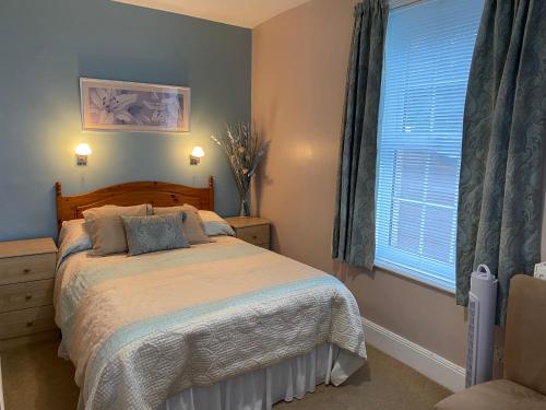 a bedroom with a bed and a window at The Belmont in Shanklin