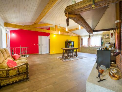 a living room with yellow and red walls and a couch at Cantinho do Lúcio in Melgaço
