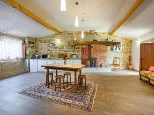 a kitchen and living room with a table and a couch at Cantinho do Lúcio in Melgaço