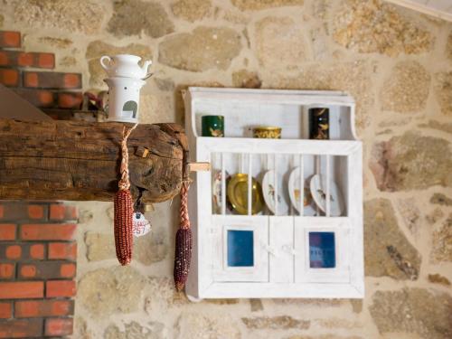 a white cabinet hanging on a brick wall at Cantinho do Lúcio in Melgaço