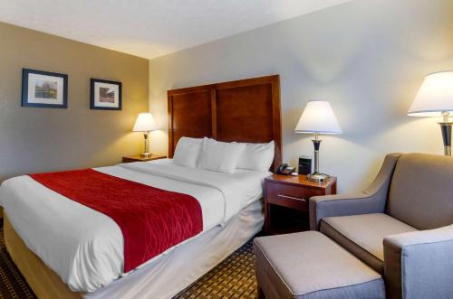 a hotel room with a large bed and a chair at Comfort Inn Atkins-Marion I-81 in Atkins