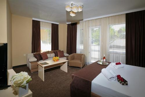 Habitación de hotel con cama y sala de estar. en HOTEL THE WHITE HOUSE Plovdiv en Plovdiv