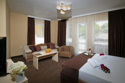 a hotel room with a bed and a living room at WHITE HOUSE Plovdiv in Plovdiv