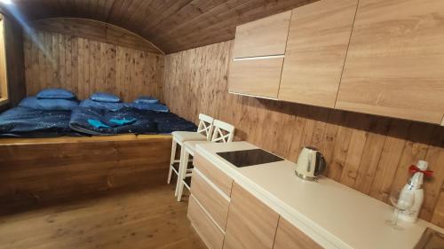 a room with a bed and a kitchen with a counter at Maringotka/tiny house SEN VYSOČINA in Věstoňovice