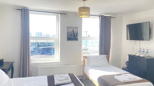 a small room with two beds and a window at Lady Hamilton Inn in Portsmouth