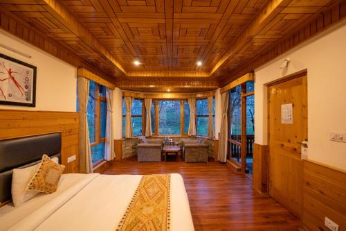 a bedroom with a bed in a room with windows at Amarys Boutique Stays Manali in Manāli