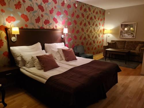 a bedroom with a large bed and a couch at Best Western Rådmannen in Alvesta