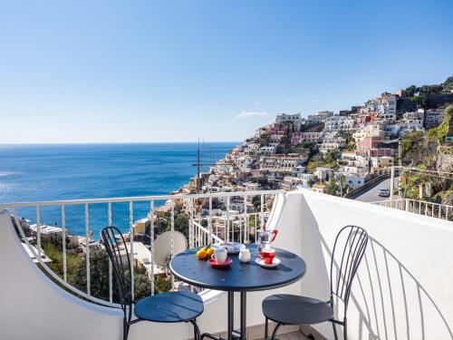 a table on a balcony with a view of the ocean at La Perla di Chicca in Positano