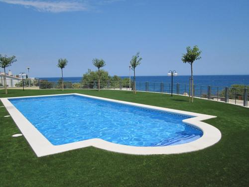 una piscina con el océano en el fondo en Apartament a les cales de Llançà en residència privada amb piscina en Llança