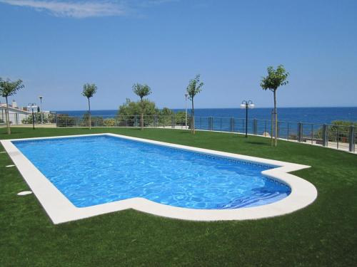 a swimming pool with the ocean in the background at La Tarongina apartament amb piscina in Llança