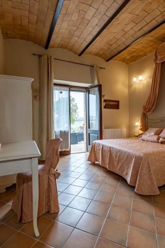 a bedroom with a bed and a table and a window at Wine Resort Colsereno in Montalcino