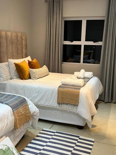 a bedroom with two beds and a window at Caribbeans Estates 76/34 in Port Edward