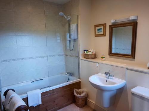 bagno con lavandino, vasca e servizi igienici di The Shippon, Parc yr Odyn, Pentraeth, Anglesey LL75 8UL a Pentraeth