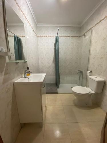 Un baño con lavabo, inodoro y ducha. en Apartamento cerca de las piscinas naturales, en Punta Mujeres