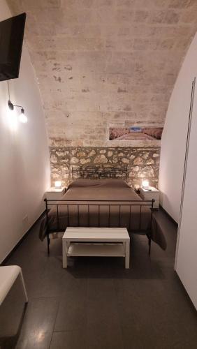ein Schlafzimmer mit einem Bett und einer Bank in einem Zimmer in der Unterkunft Casa Vittoria in Palazzolo Acreide
