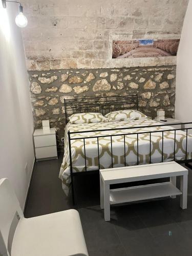 - une chambre avec un lit et un banc dans l'établissement Casa Vittoria, à Palazzolo Acreide