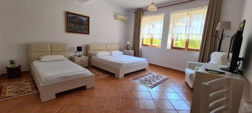 a living room with two beds and a television at Veranda B&B in Berat