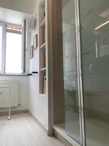 La salle de bains est pourvue d'une douche en verre et d'une fenêtre. dans l'établissement Le Metz, Duplex, 2 Chambres, à Le Touquet-Paris-Plage