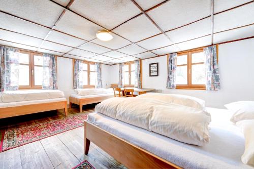 a bedroom with two beds and a living room with windows at Pfefferhütte in Marul