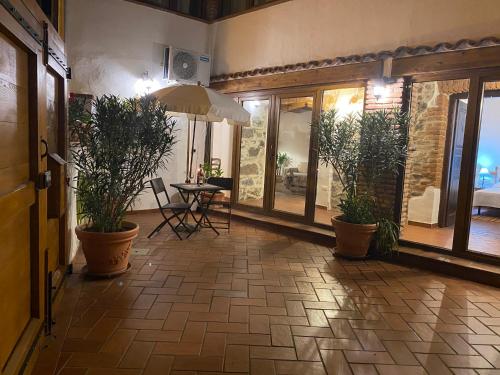 um corredor com vasos de plantas e uma mesa com guarda-chuva em Casa Raimondo em Orosei