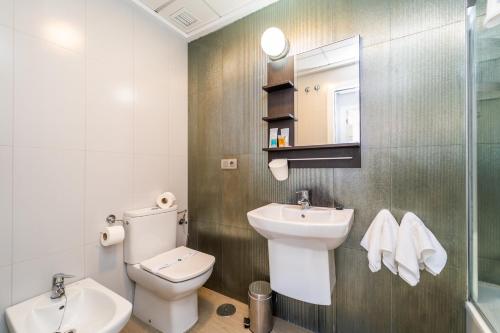 a bathroom with a toilet and a sink at Vistamar Luxury Apartments By DLV -Adults Only- in Villajoyosa