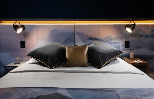 a bedroom with a large bed with two pillows at Boutique Hotel Glacier in Grindelwald