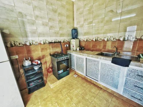 una pequeña cocina con fogones y fregadero en Atiaf Jabal Shams house, en Misfāh