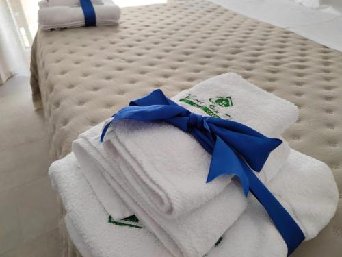 - une pile de serviettes avec un arc bleu sur un lit dans l'établissement Casa Vacanze Vicolo San Pietro, à Agrigente