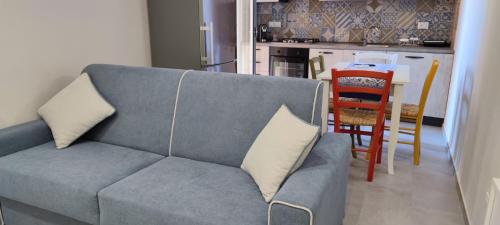 a living room with a blue couch and a kitchen at Casa Vacanze Vicolo San Pietro in Agrigento