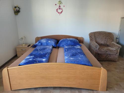 a bedroom with a bed with blue pillows and a chair at Mickten Hertz in Dresden