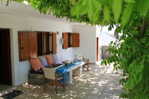 eine Terrasse mit einem Tisch und Stühlen in einem Haus in der Unterkunft Traditional Olive House in Makry Gialos