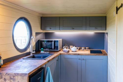 a kitchen with a sink and a microwave at north fell under the stars in Morpeth