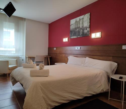 a bedroom with a large bed with two towels on it at Hotel Cuéntame in Burgos