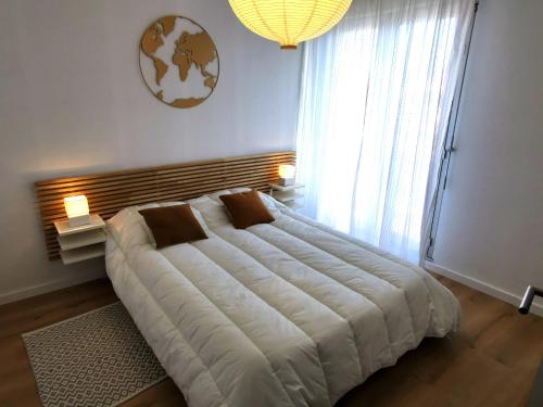 un grand lit dans une chambre avec une grande fenêtre dans l'établissement LES ROCHES BRUNES - Face Mer, à Les Sables-dʼOlonne