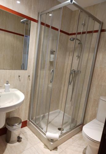 a shower in a bathroom with a toilet and a sink at Hotel Cuéntame in Burgos