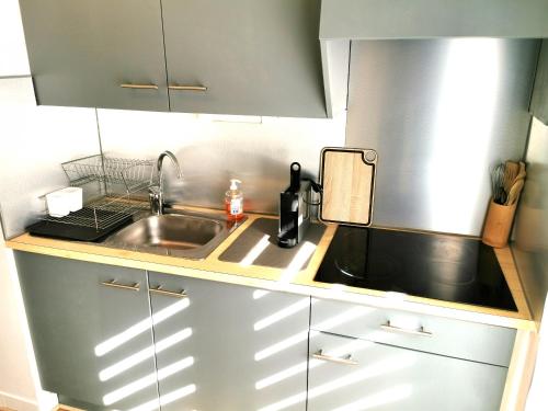 une petite cuisine avec un évier et un comptoir dans l'établissement LES ROCHES BRUNES - Face Mer, à Les Sables-dʼOlonne