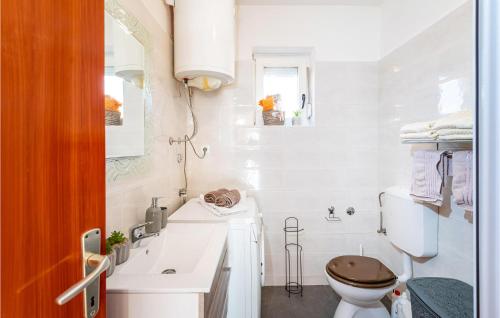 Baño blanco con aseo y lavamanos en Lovely Apartment In Jasenice With Kitchen en Jasenice