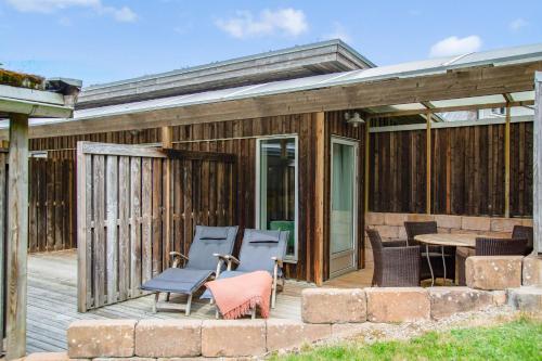 a deck with chairs and a table on a house at Hotell och Restaurang Hovs Hallar in Båstad