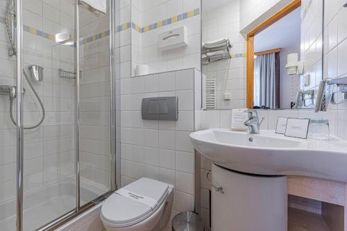 y baño con aseo, lavabo y ducha. en Hotel Nosalowy Dwór, en Zakopane