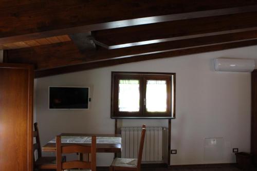 uma sala de jantar com uma mesa e uma janela em The Chalet, guest house em Agerola